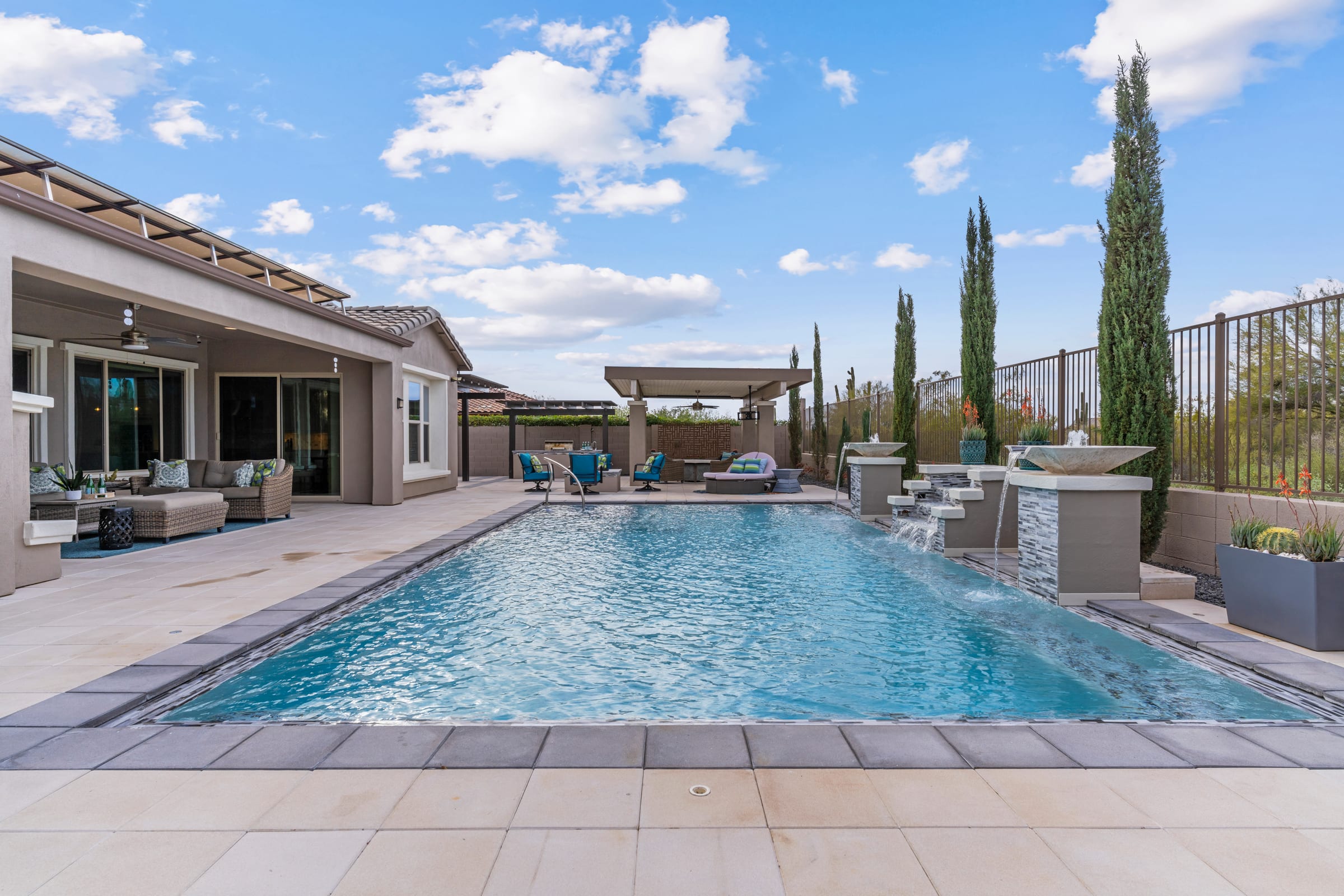 Pool terrace lined with cypress, covered patio beyond