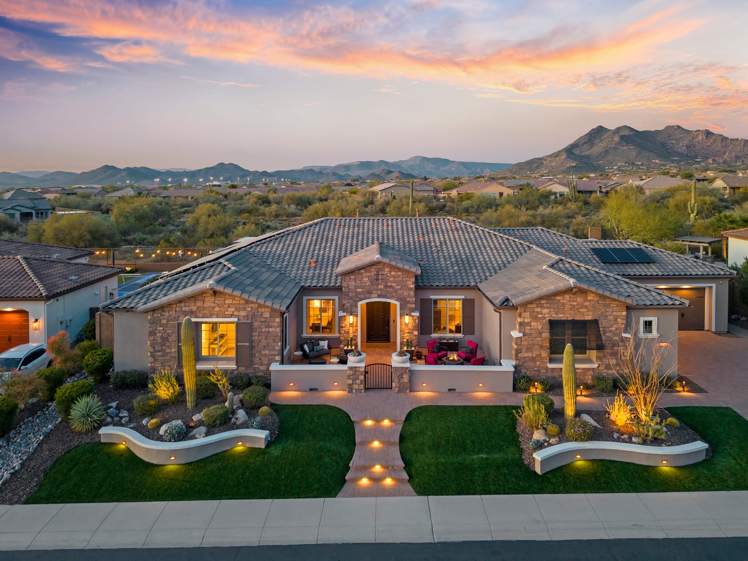 Stone-and-stucco estate lit at dusk in the Cave Creek foothills